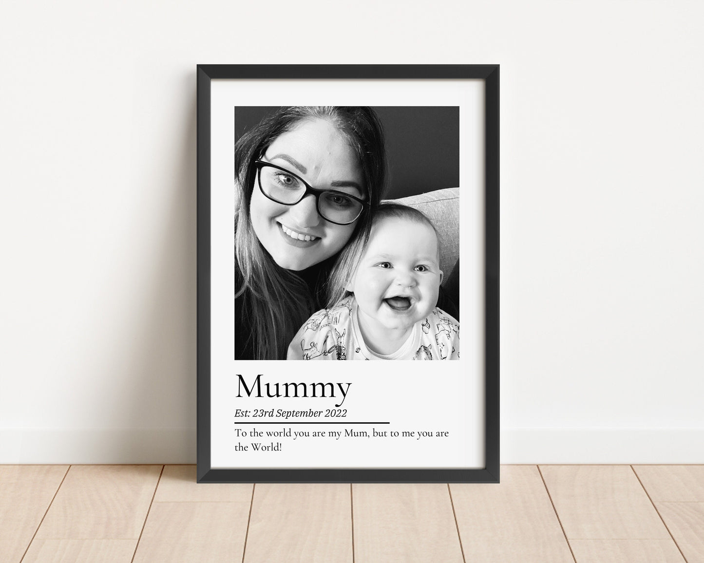 A stunning black and white photo print with the word Mummy underneath, then the date established and a quote that reads to the world you are my Mummy, but to me you are the world'.