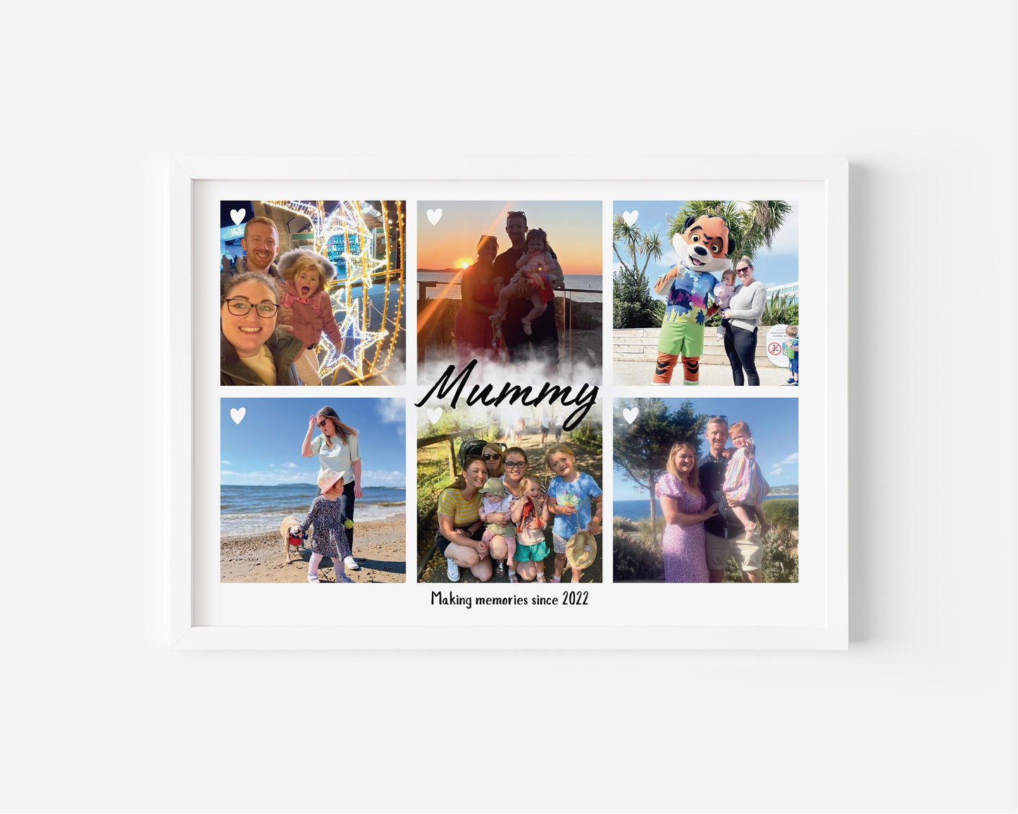 A framed personalized photo collage featuring six family pictures arranged in a grid. The center of the collage has the word 'Mummy' written in elegant script, with the phrase 'Making memories since 2022' below it. The photos capture various moments, including beach outings, family gatherings, and fun activities with a child. The frame is white, and small heart icons are placed on some of the images, adding a sentimental touch.